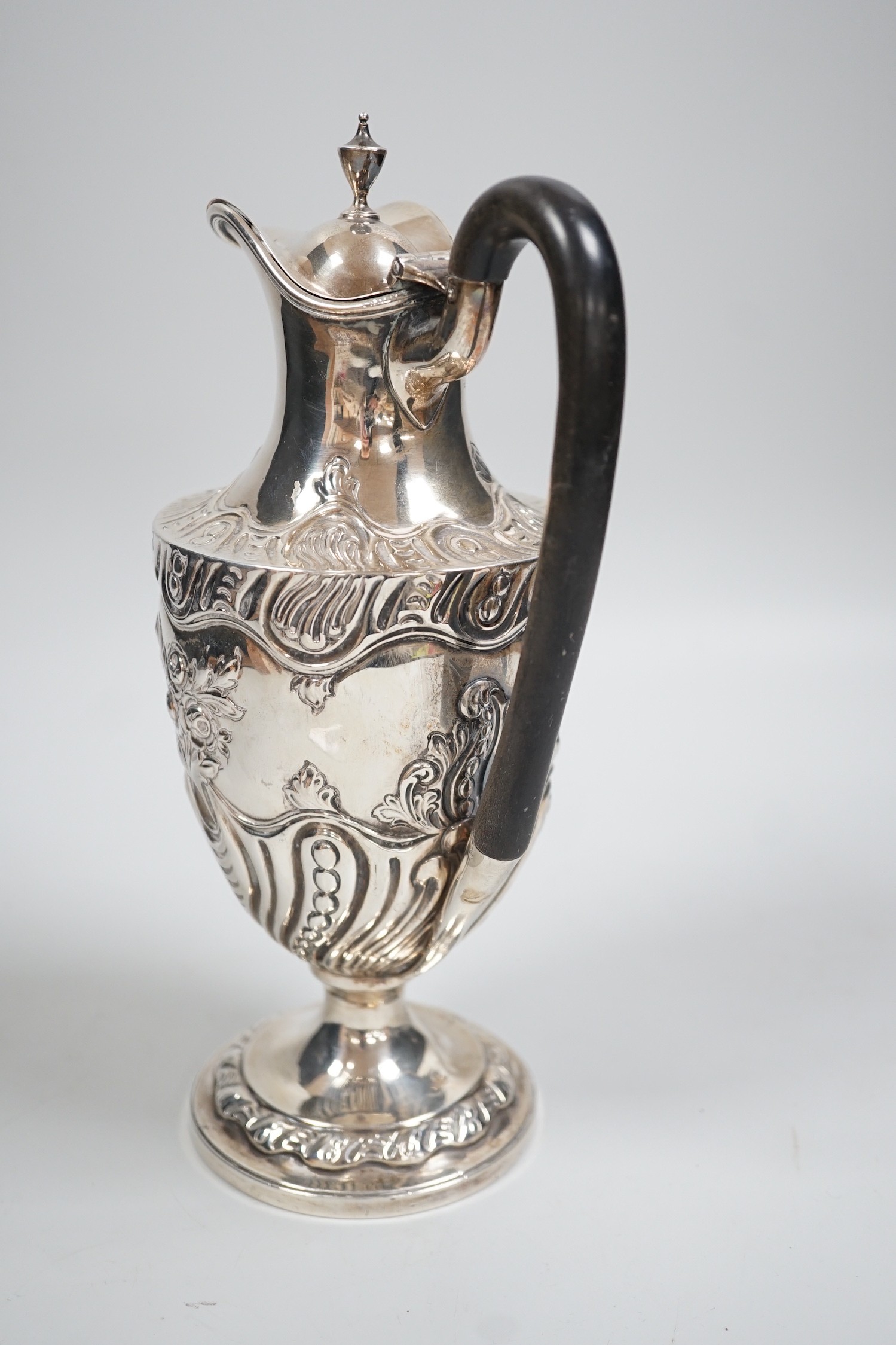 A late Victorian repousse silver pedestal hot water jug, Charles Stuart Harris, London, 1893, height 25cm, gross weight 13.3oz.